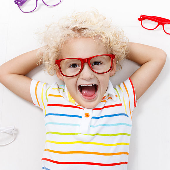 Child at eye sight test. Little kid selecting glasses at optician store. Eyesight measurement for school kids. Eye wear for children. Doctor performing eye check. Baby with spectacles top view.